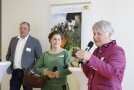 Zwei Frauen und ein Mann stehen bei einer Podiumsdiskussion an Stehtischen.